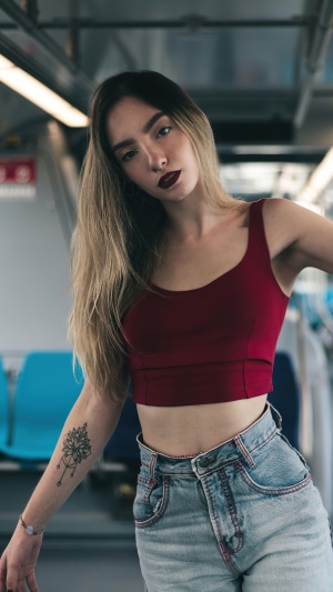 Woman in crop top and jeans on a train