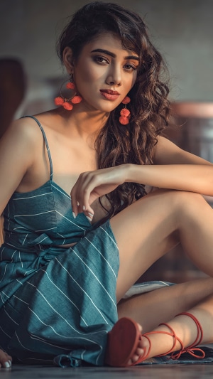 Model in a blue striped dress with orange earrings