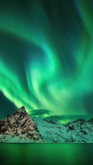 Aurora Borealis over snow-capped mountains and water