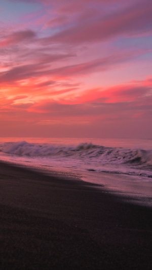Sunset over the ocean with waves and beach