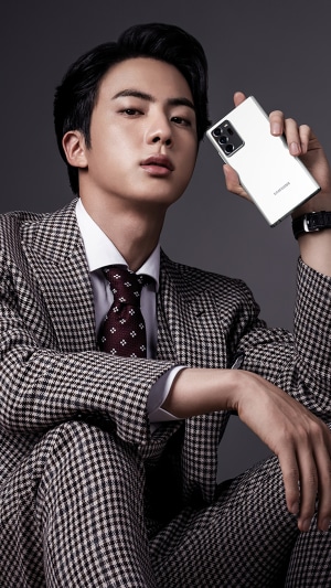 Jin from BTS holding a Samsung phone