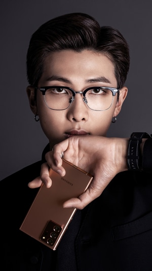 RM from BTS holding a Samsung phone