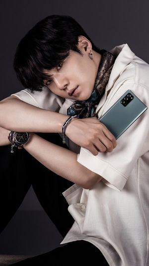 Suga from BTS holding a Samsung phone