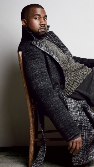 Kanye West wearing a coat and sweater