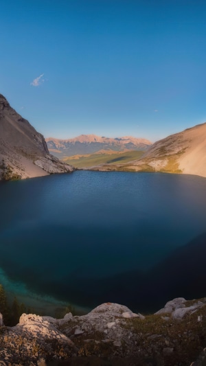 Lake surrounded by mountains and rocky shore