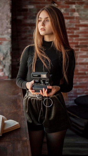 Girl holding a Polaroid camera