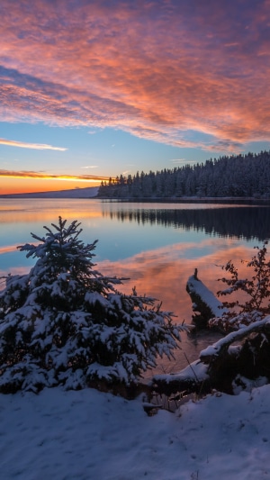 Snowy lake at sunset with colorful clouds