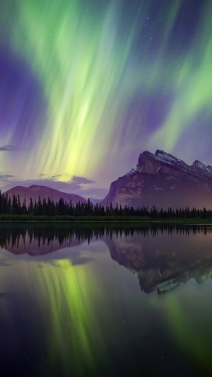 Aurora Borealis over mountains and lake