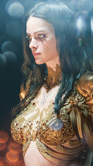 Woman in ornate golden armor with dark makeup