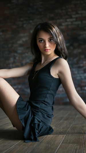 Girl in black dress and fishnet stockings