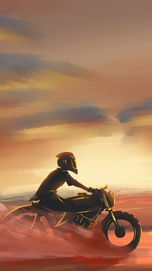 Motorcyclist riding through a desert at sunset