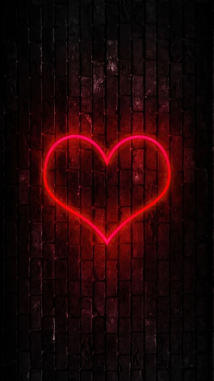 Red neon heart on a dark brick wall