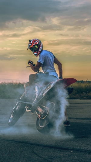 Motorcyclist doing a wheelie with smoke
