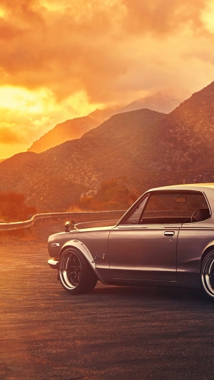 Classic car on a mountain road at sunset
