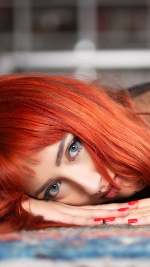 Redhead model with blue eyes lying down