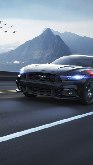 Black Ford Mustang driving on a mountain road