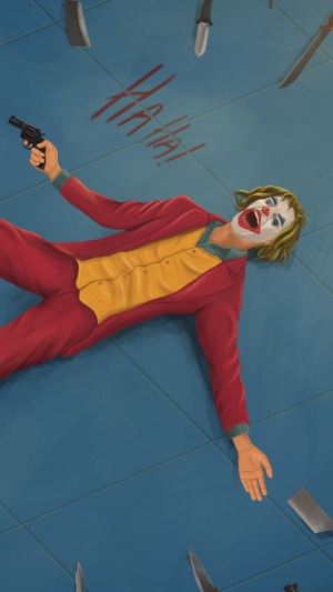 Joker lying on the floor with a gun and knives
