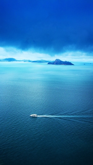 Boat sailing on the ocean with islands in the background 4K
