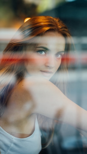 Young woman with blonde hair looking through a window