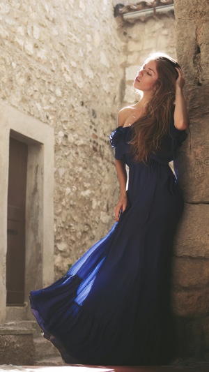 Woman in a blue dress in an alley