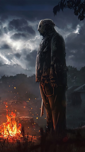 Jason Voorhees standing by a campfire during a thunderstorm