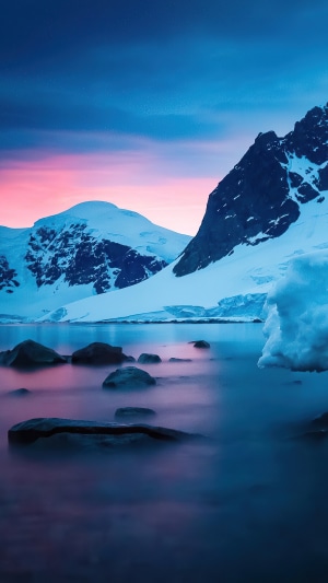Snowy mountains and ocean at sunset 4K