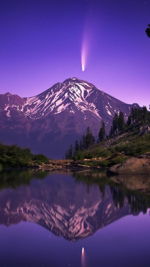 Mountain lake with comet and stars