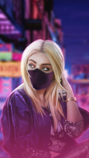 Blonde girl wearing a mask in a city at night
