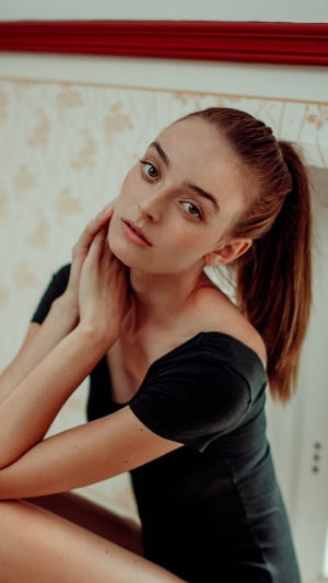 Model with brown hair in a black top