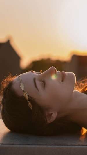 Woman with golden leaf headband at sunset