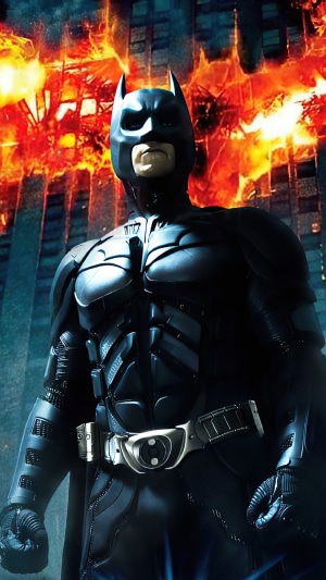 Batman in front of burning buildings