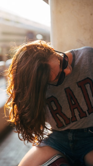 Girl with long hair wearing sunglasses and a t-shirt