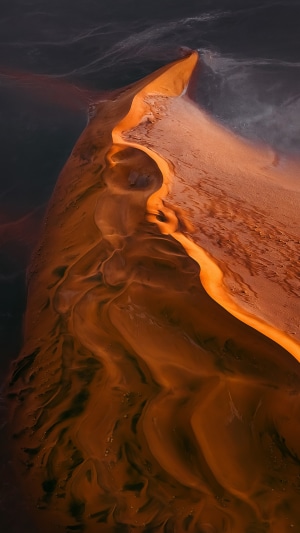 Aerial view of desert sand dunes and water