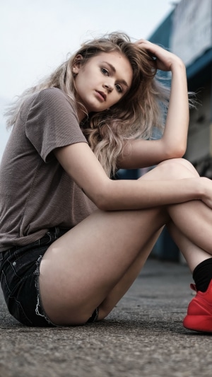 Young woman with blonde hair wearing a t-shirt and shorts