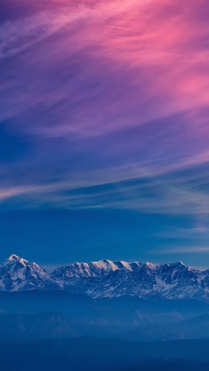 Snow-capped mountains under a pink and purple sky