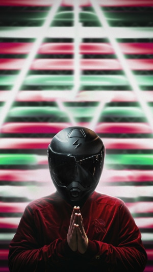 Person in biker helmet praying with abstract background
