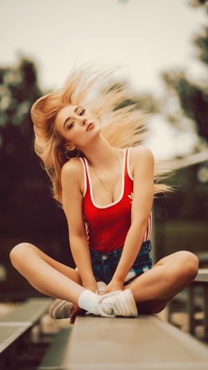 Blonde model in red tank top and denim shorts