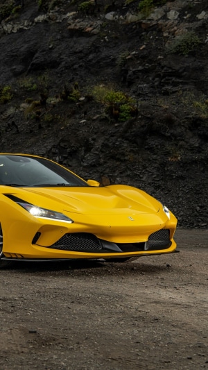 Yellow Ferrari F8 Tributo on a dirt road
