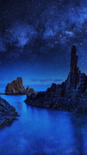Rocky coast under a starry night sky