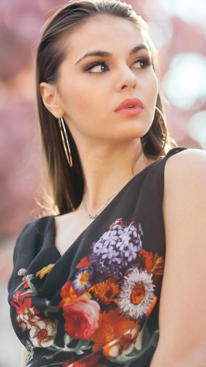 Model with floral dress and hoop earrings