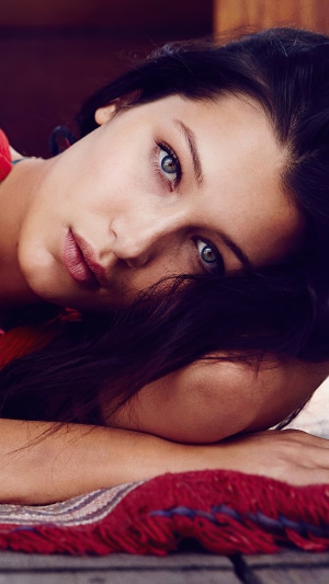 Bella Hadid lying down on a rug