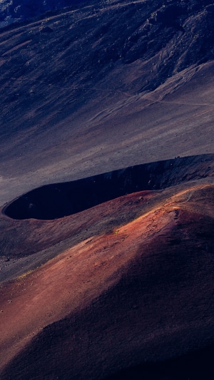 Volcanic crater landscape with red and dark soil