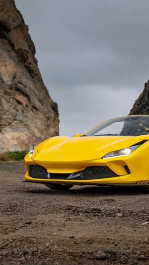 Yellow Ferrari F8 Tributo parked on a dirt road