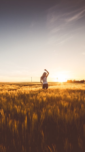 Woman in a field at sunset