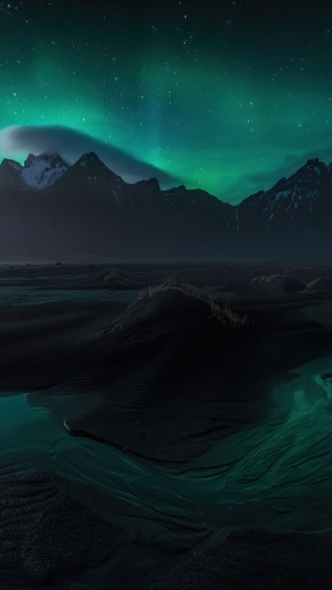 Northern Lights over Mountains and Dark Landscape