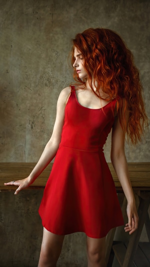 Model with long red hair in a red dress