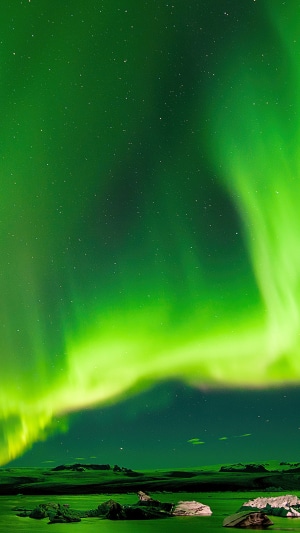 Aurora Borealis over a body of water with icebergs