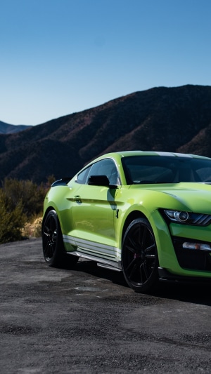 Green Ford Mustang GT500 parked on a mountain road