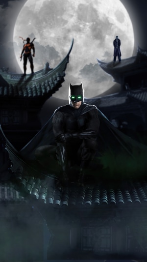 Batman and two ninjas on rooftops under a full moon