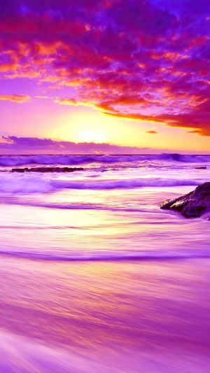 Purple sunset over the ocean with waves